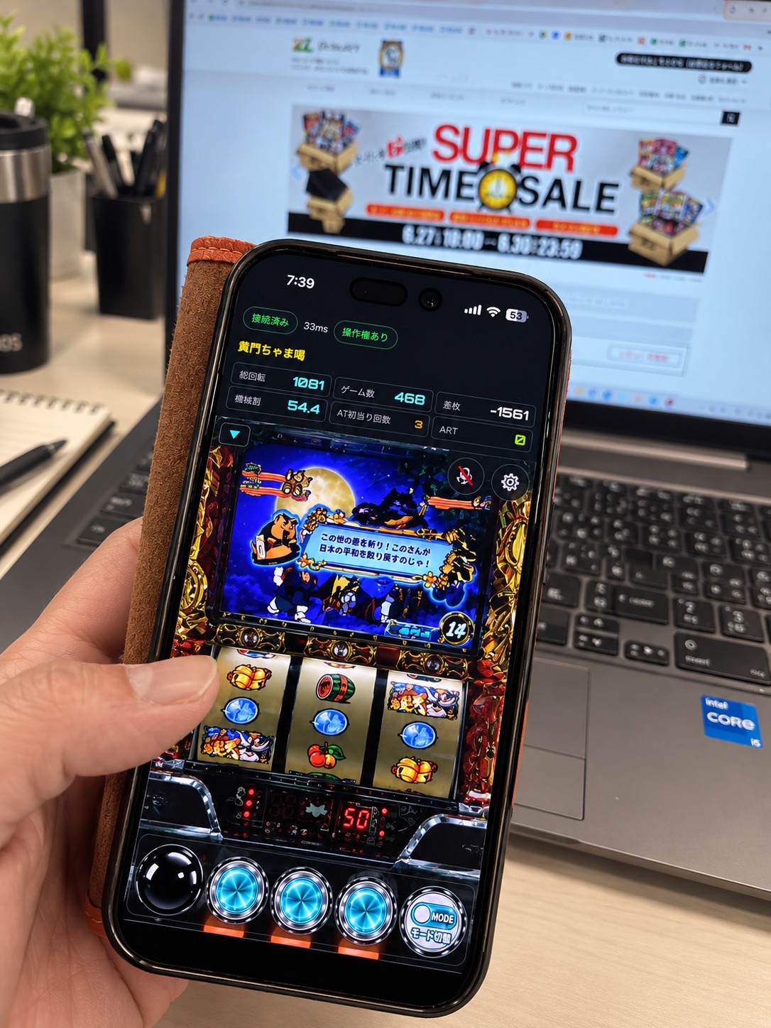 仕事の休憩時間に、デスクでスマホから自宅の実機を遊んでいる様子